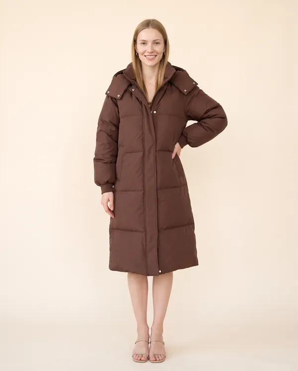 Long Hooded Puffer Coat in Chocolate, front view, worn by Maya