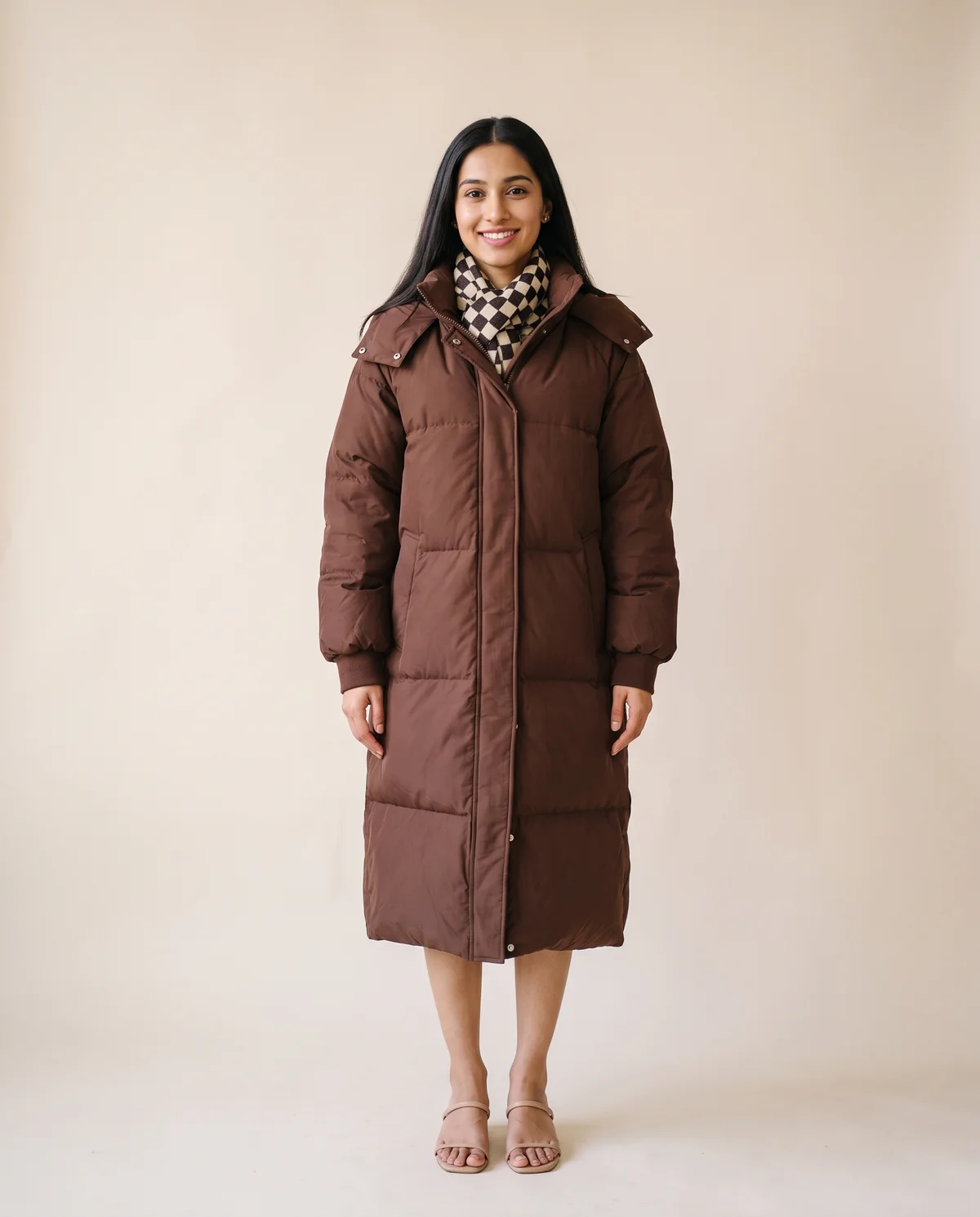 Long Hooded Puffer Coat in Chocolate, front view, worn by Priya