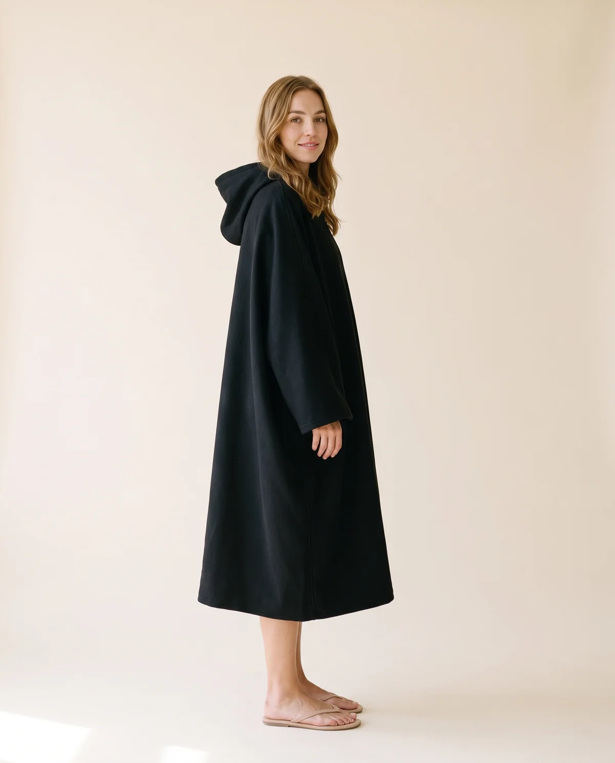 Hooded Cape Coat in Black, side view, worn by Ava