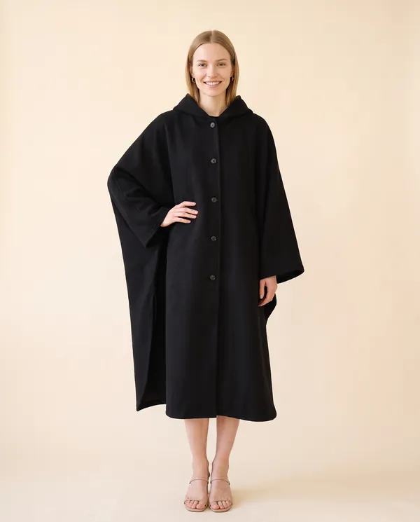 Hooded Cape Coat in Black, front view, worn by Maya