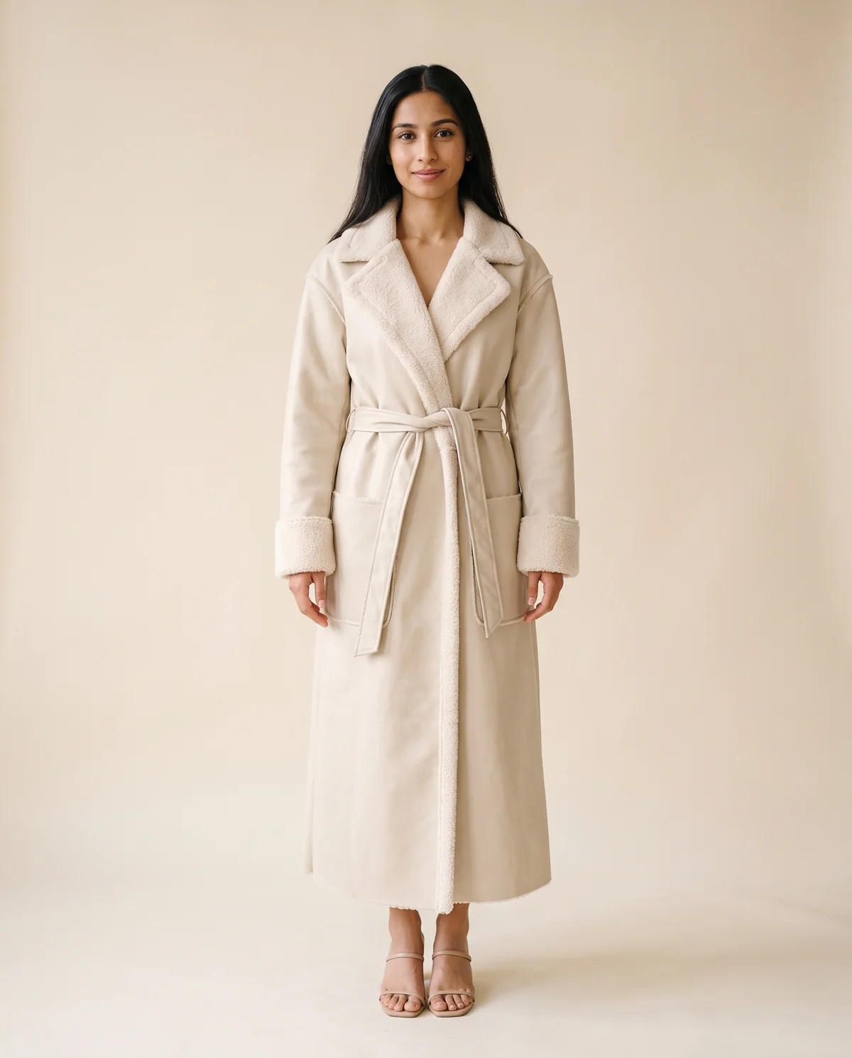 Belted Long Faux Leather Coat in Cream, front view, worn by Priya