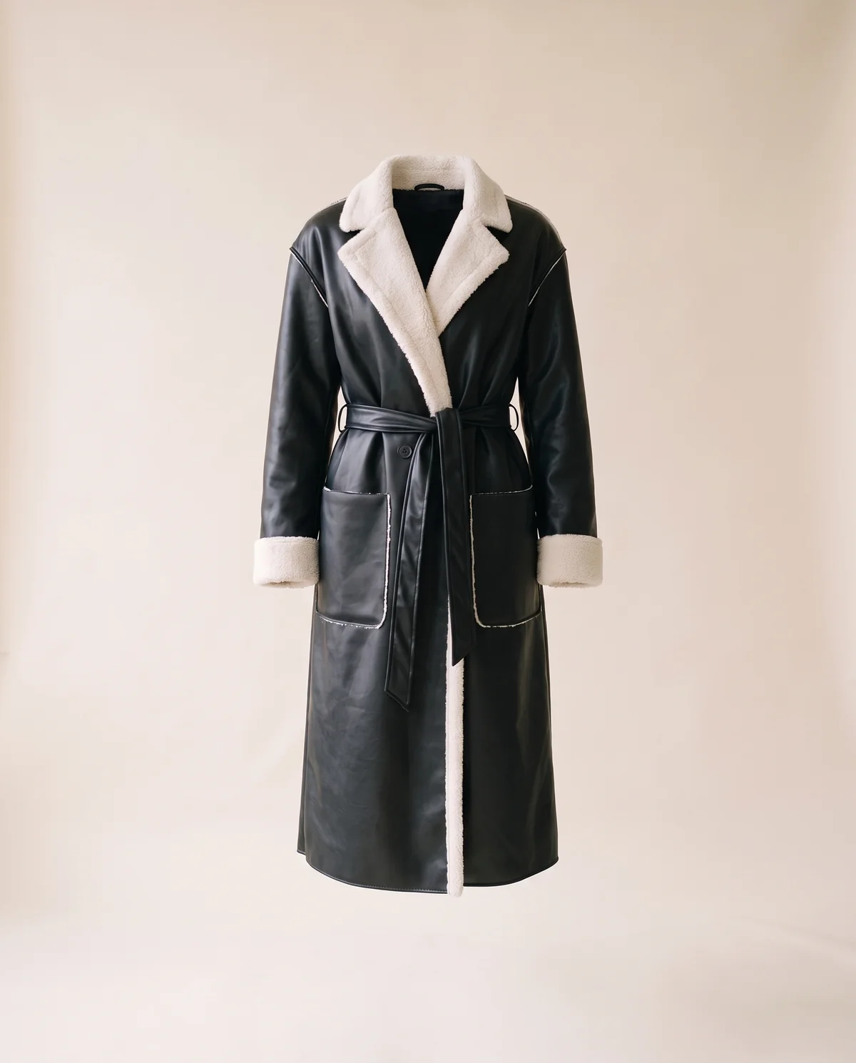 Belted Long Faux Leather Coat in Black, product shot on a plain background