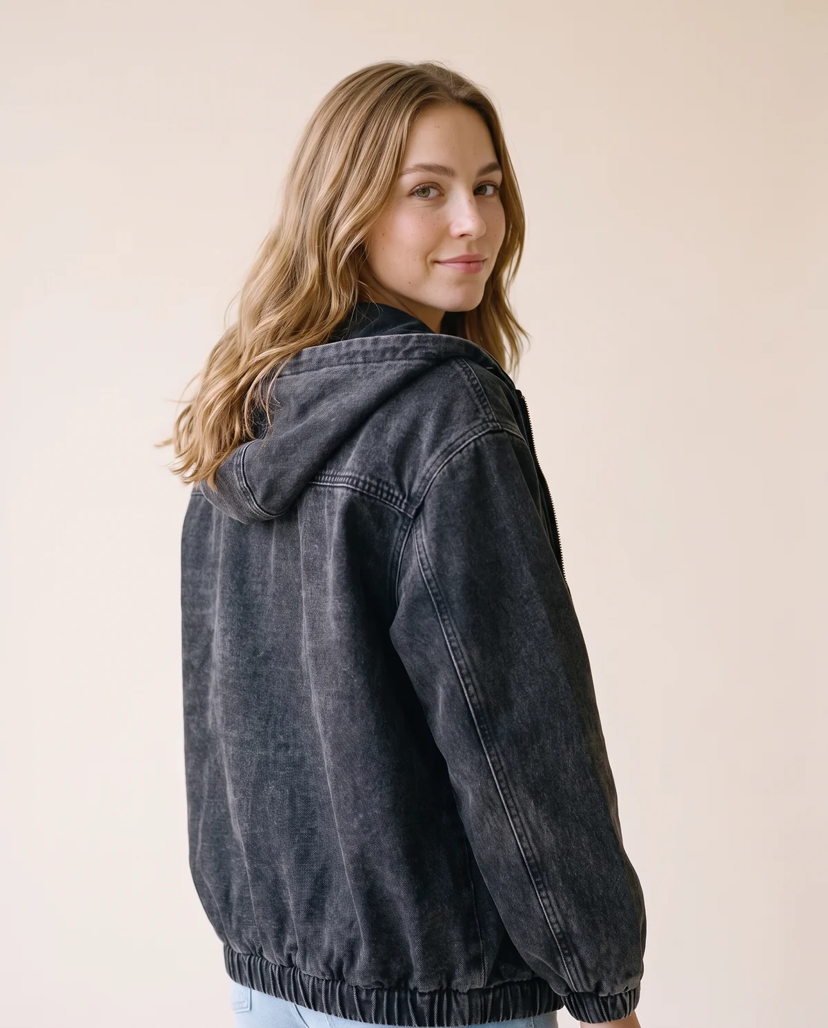 Washed Denim Hooded Zip Bomber in Washed Black, back view, worn by Ava