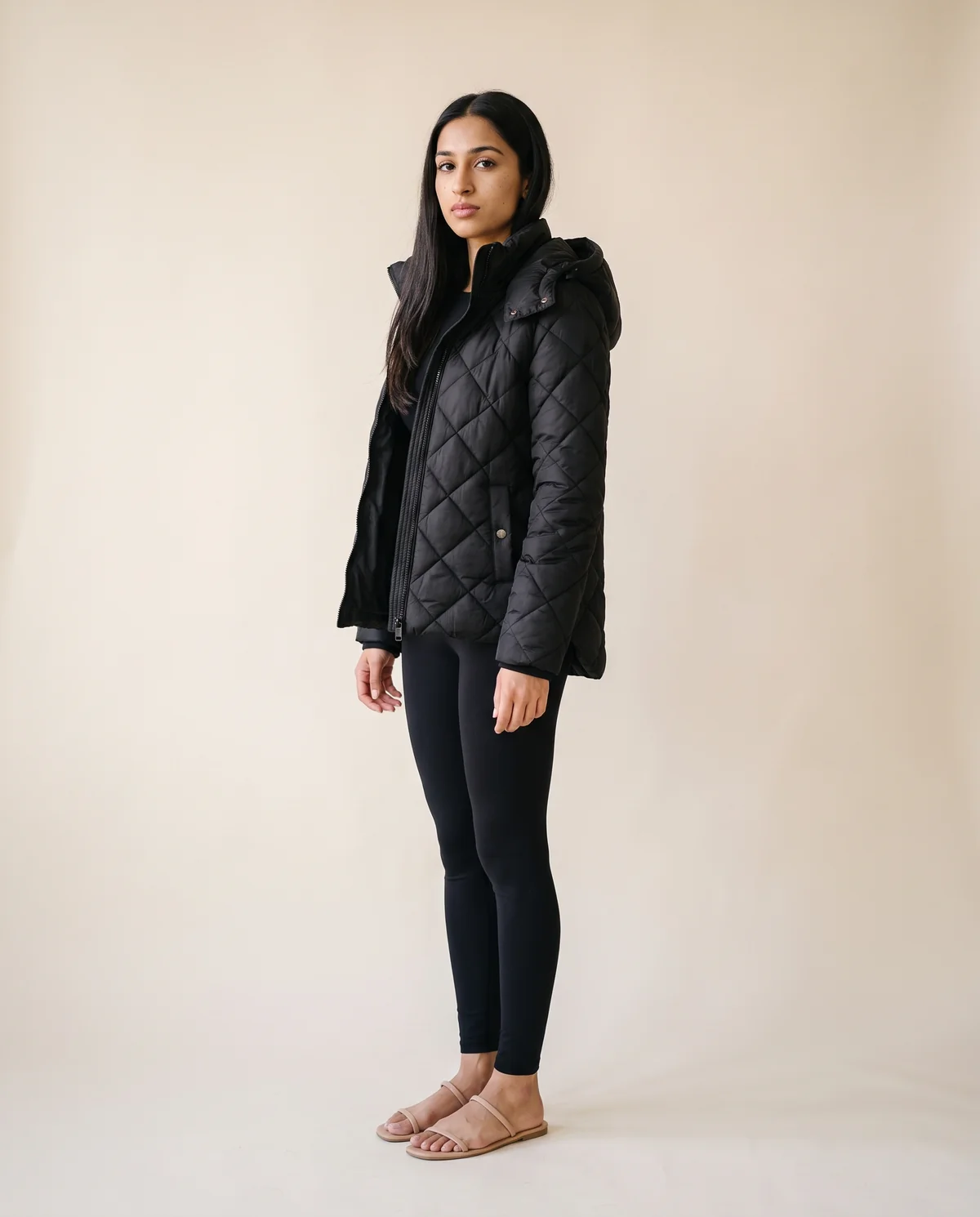 Diamond-Quilted Hooded Jacket in Black, side view, worn by Priya